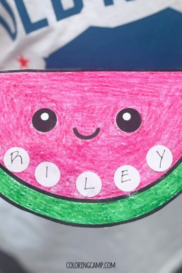 A child holding a watermelon themed Summer Name Craft.