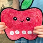 A child holding the back to school name craft.
