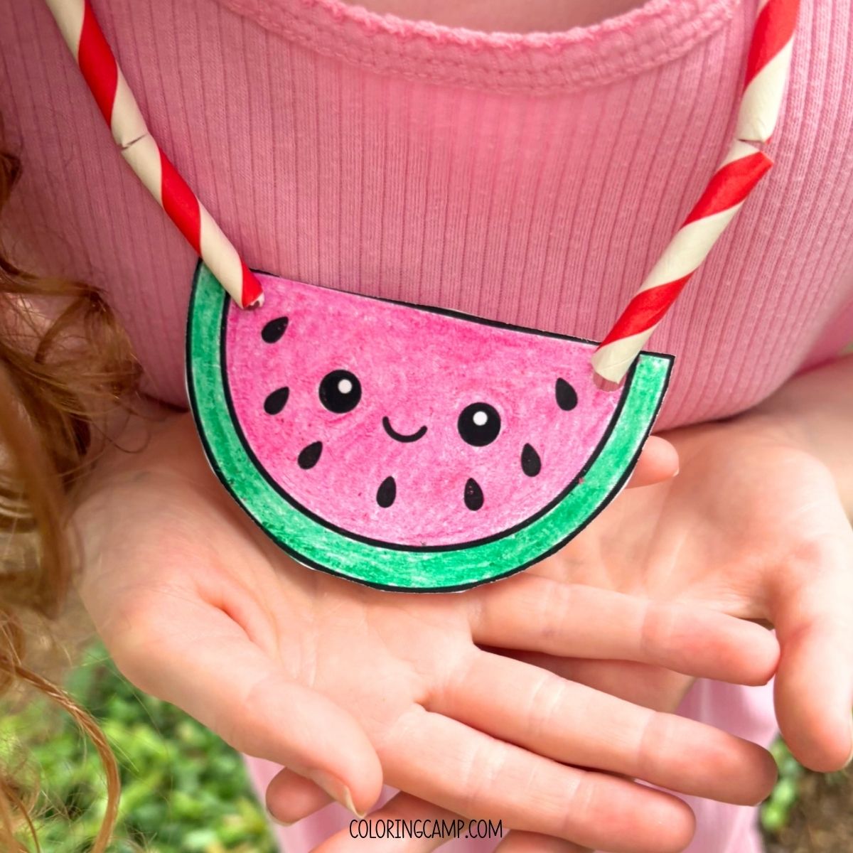 A child holding the summer necklace craft.