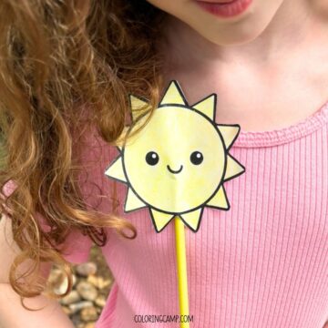 A child holding a summer wand craft (a sunshine template on a paper straw).
