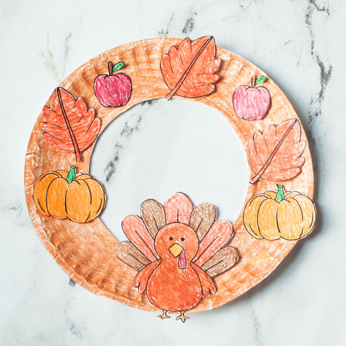 Thanksgiving themed paper plate wreath on a marble background.